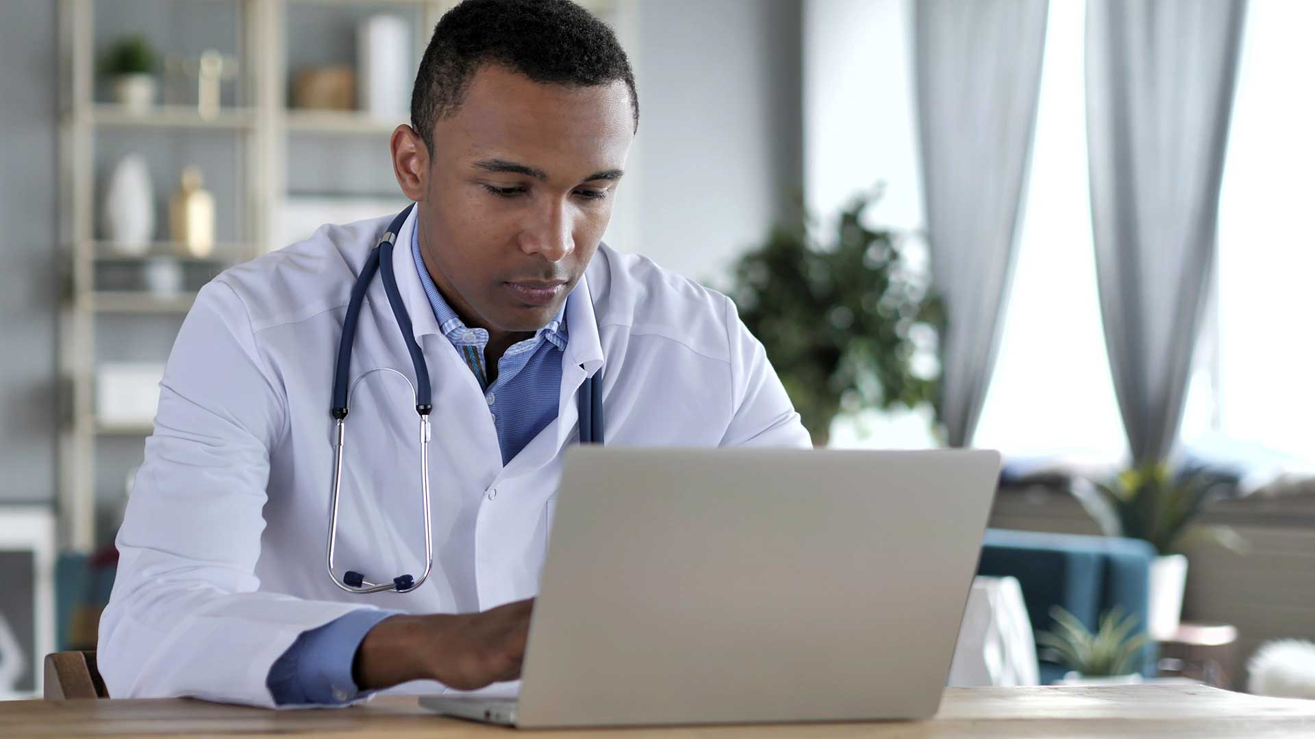 Photo of a doctor working on a laptop.